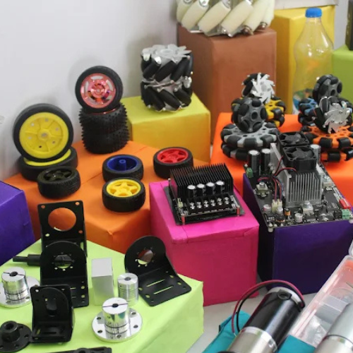 Various robotics wheels, clamps, and coupling components neatly organized on shelves in Robu office.